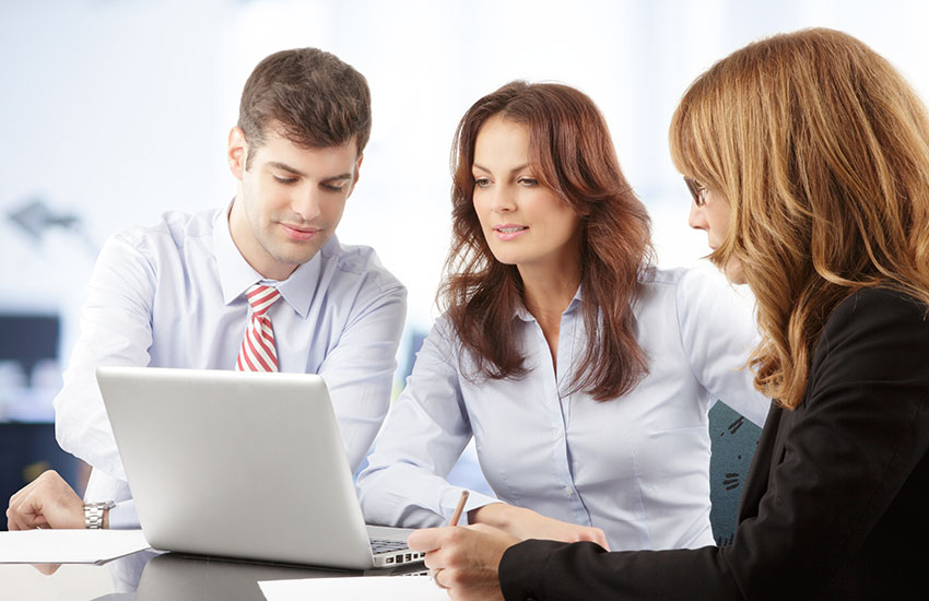 Agents at table looking at laptop
